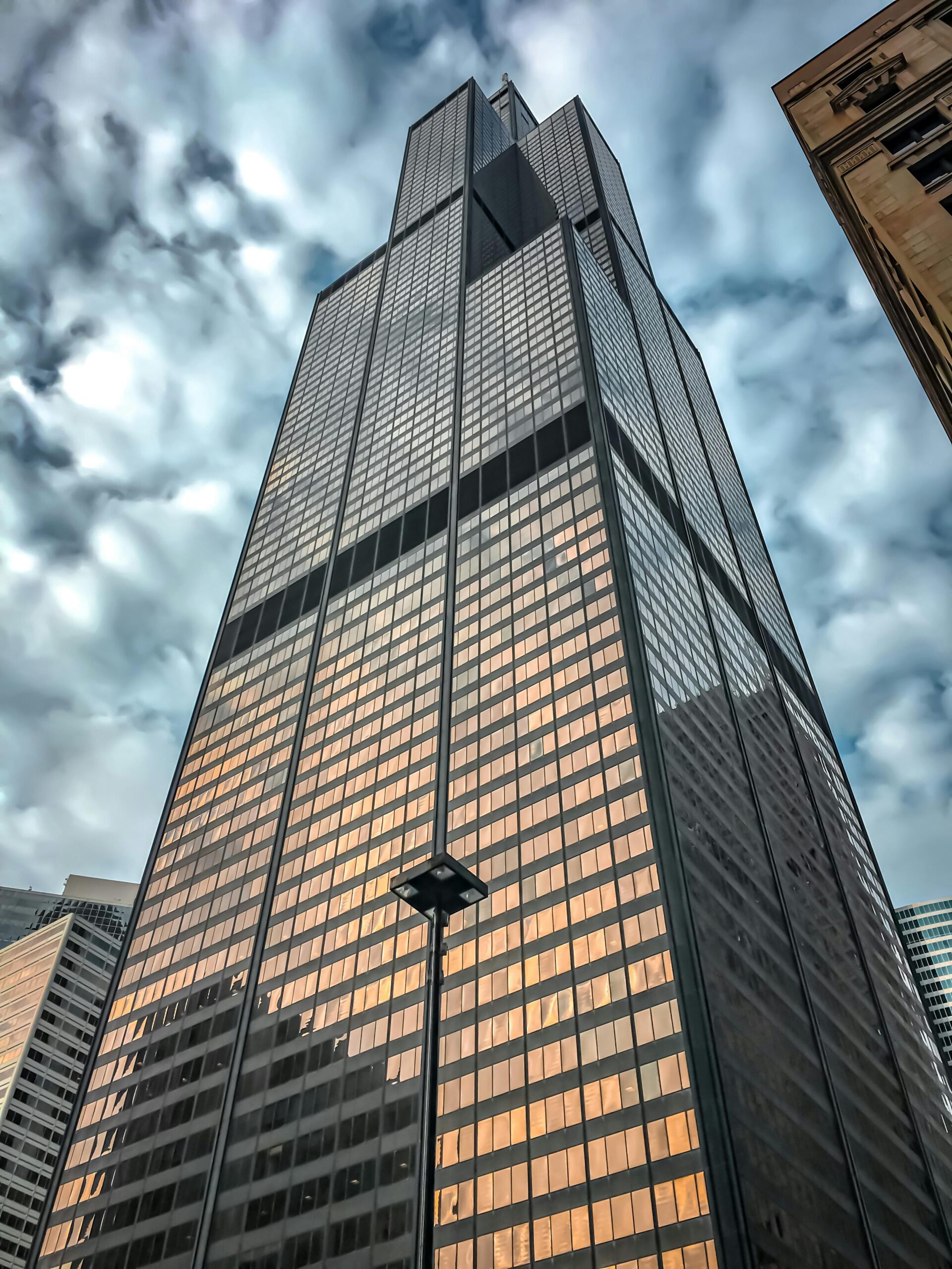 Low angle shot of Willis Tower in Chicago with dramatic clouds.